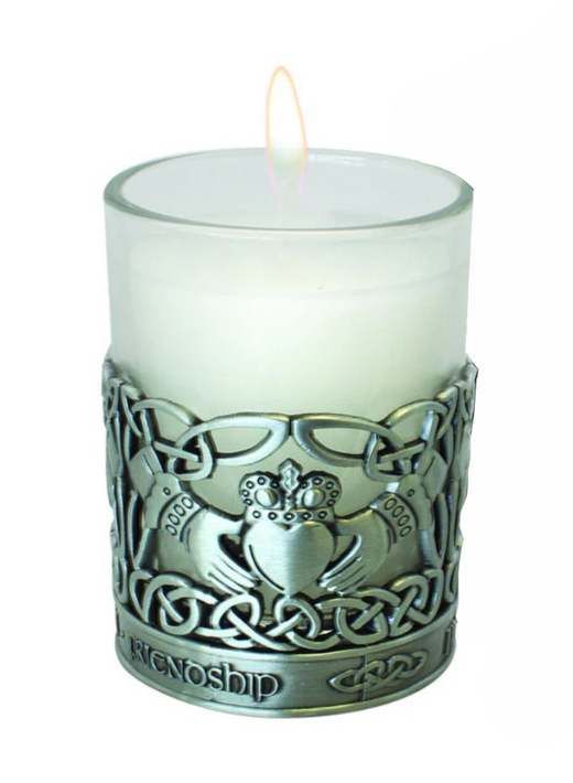 Lit white candle in glass holder with Celtic friendship design