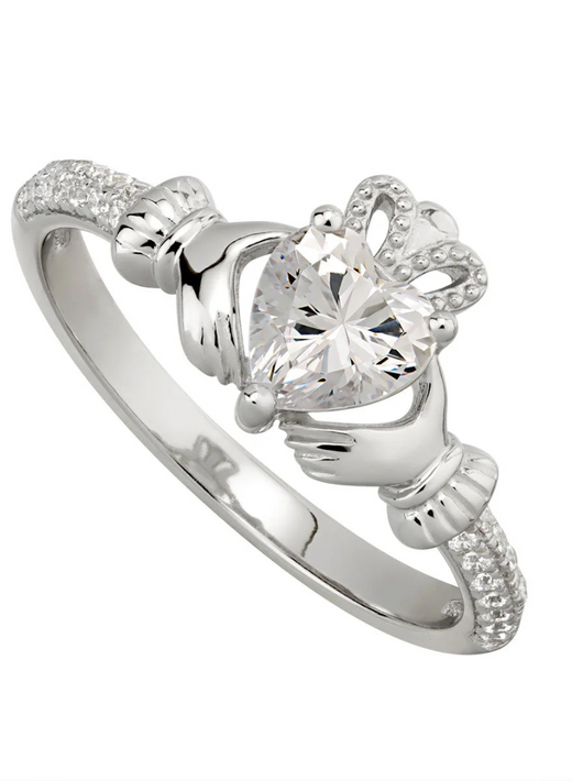 Silver ring with heart-shaped clear gemstone held by two hands and a crown