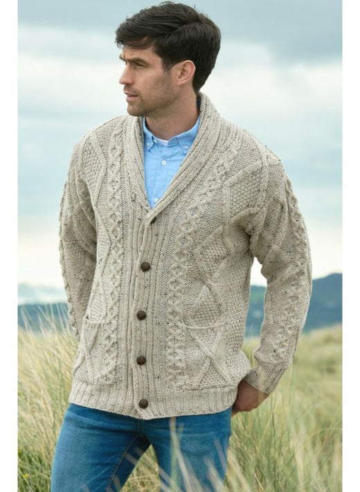 Man wearing beige cable knit cardigan with shawl collar standing outdoors