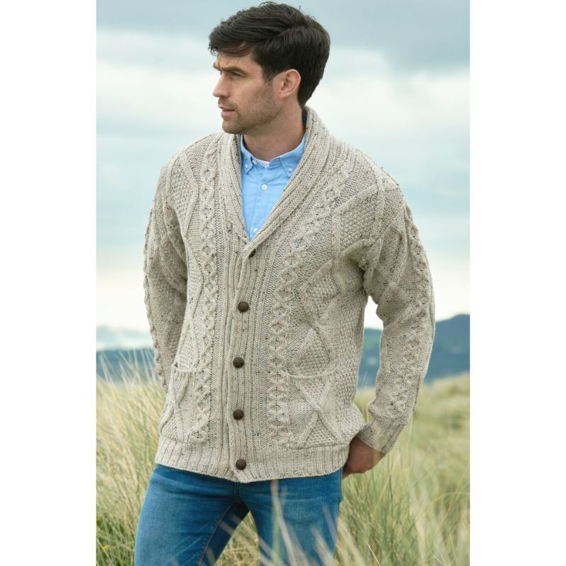 Man wearing beige cable knit cardigan with shawl collar standing outdoors