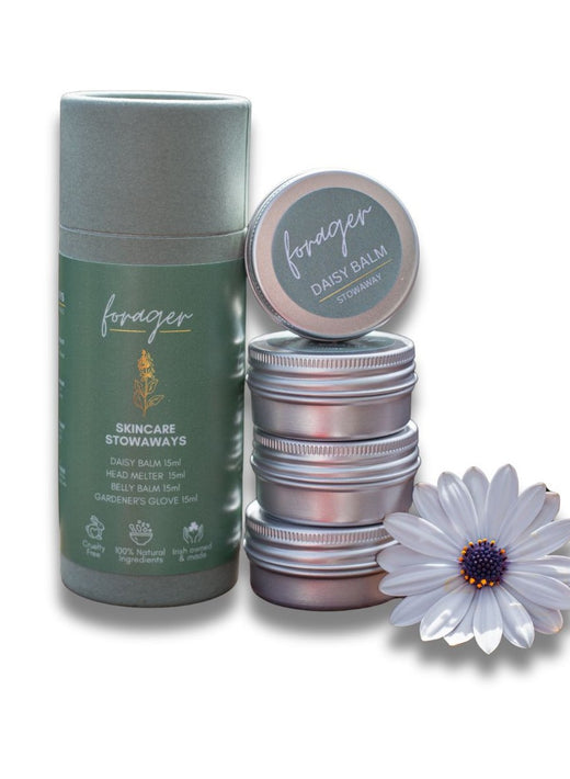 Stack of metal tins and green skincare container with white daisy flower