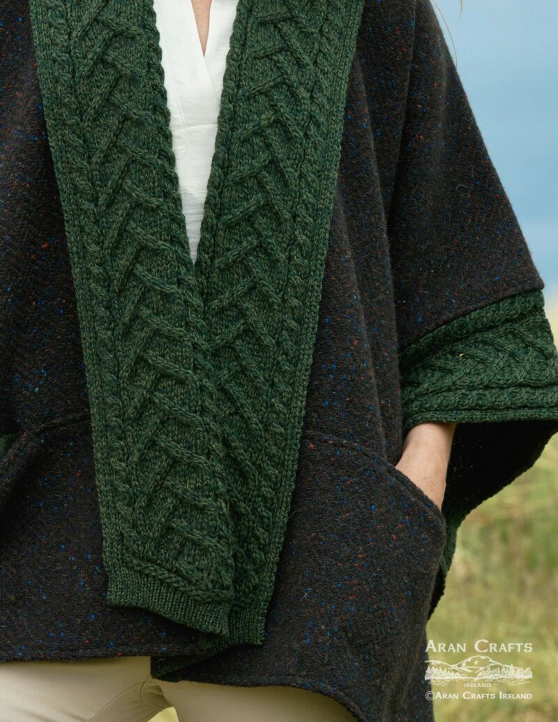 Close up of green braided cable trim along the front of the dark speckled cape