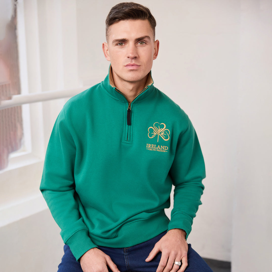 Man wearing green quarter-zip sweatshirt with Ireland Celtic Nation logo