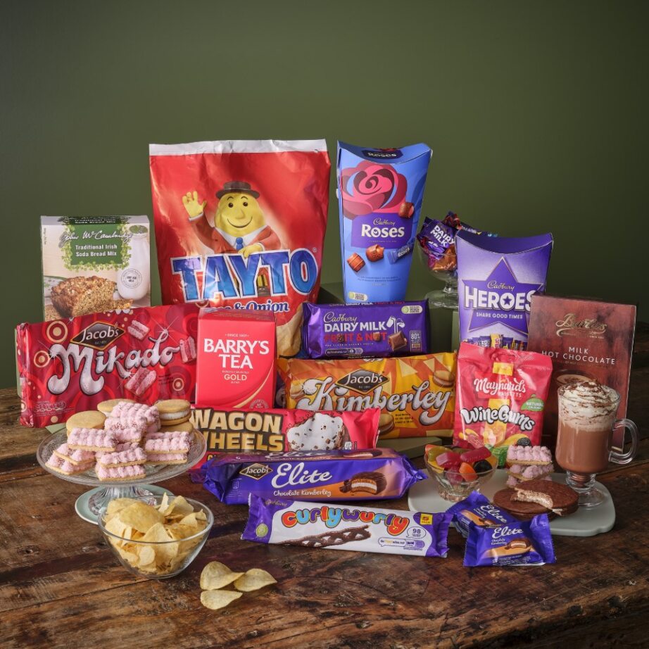 Assortment of snacks, sweets, tea, and hot chocolate on wooden table