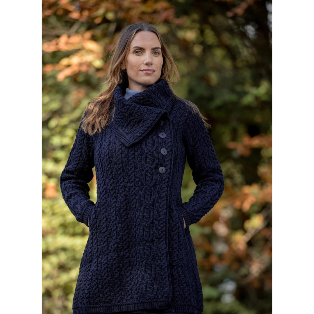 Woman wearing a navy blue cable knit sweater coat outdoors
