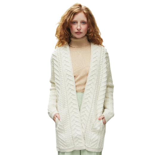 Woman with red hair wearing a cream cable knit cardigan and beige turtleneck