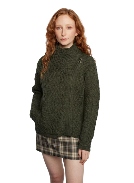 Woman with red hair wearing a green cable knit sweater and plaid skirt