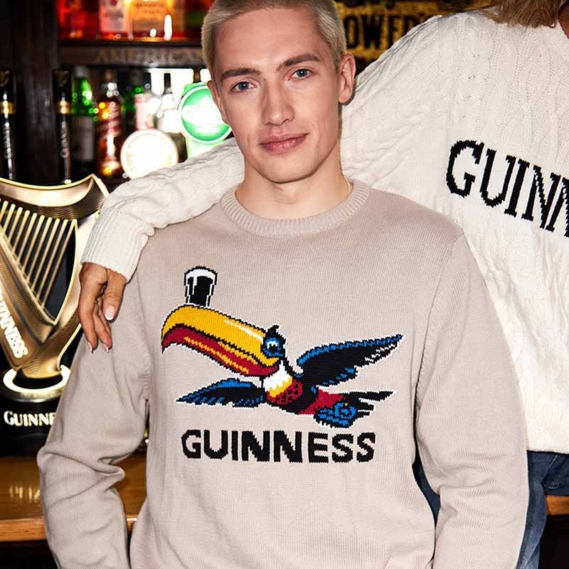 Male model wearing the Guinness Flying Toucan crew neck jumper in a bar setting