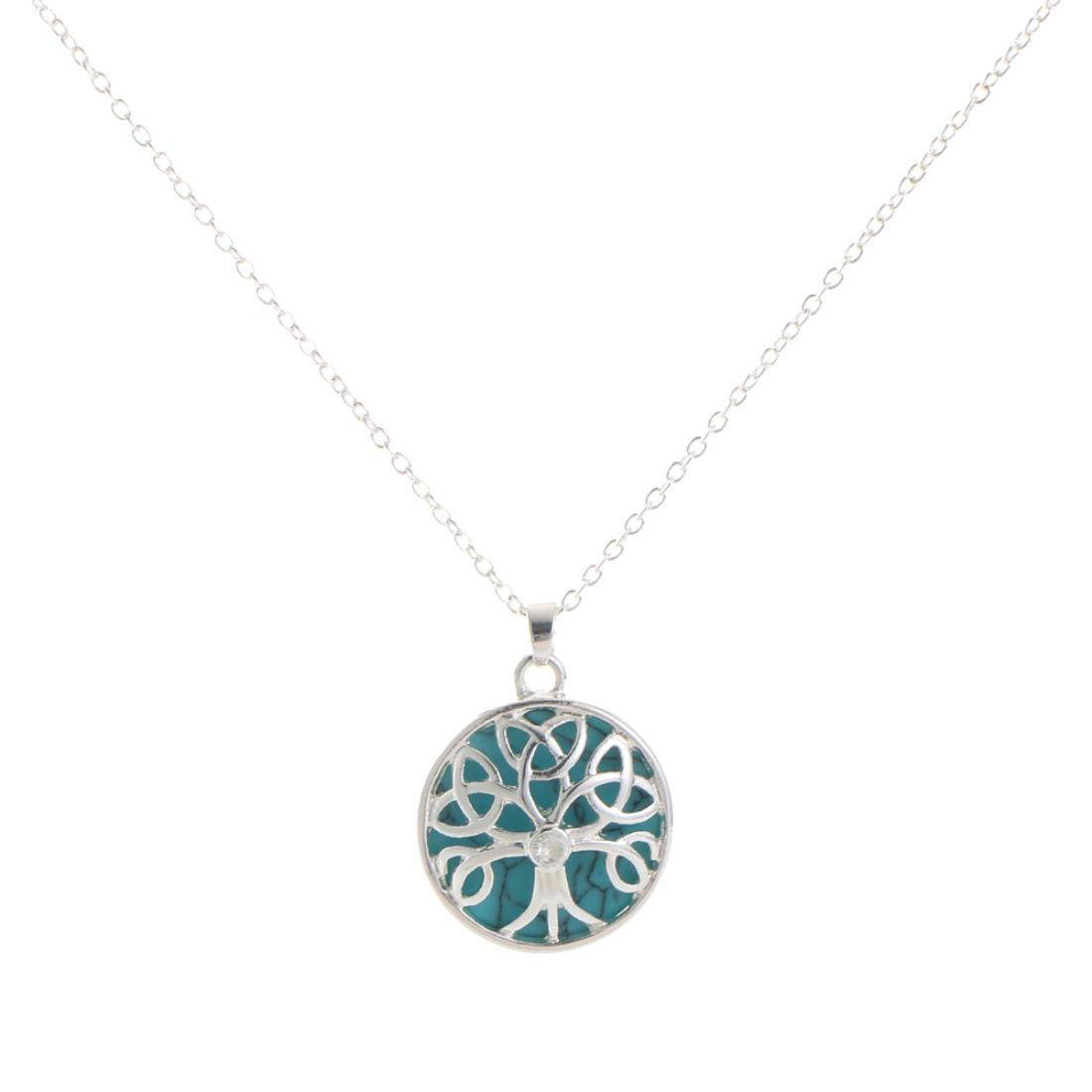 Silver necklace with round pendant featuring tree design on turquoise background